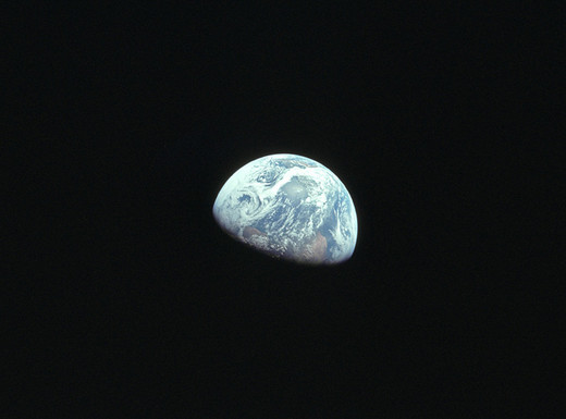 Die Abbildung zeigt die Erde, aufgenommen aus der Mondumlaufbahn während der Apollo 8-Mission im Jahr 1968. Die Fotoaufnahme stammt von William Anders.