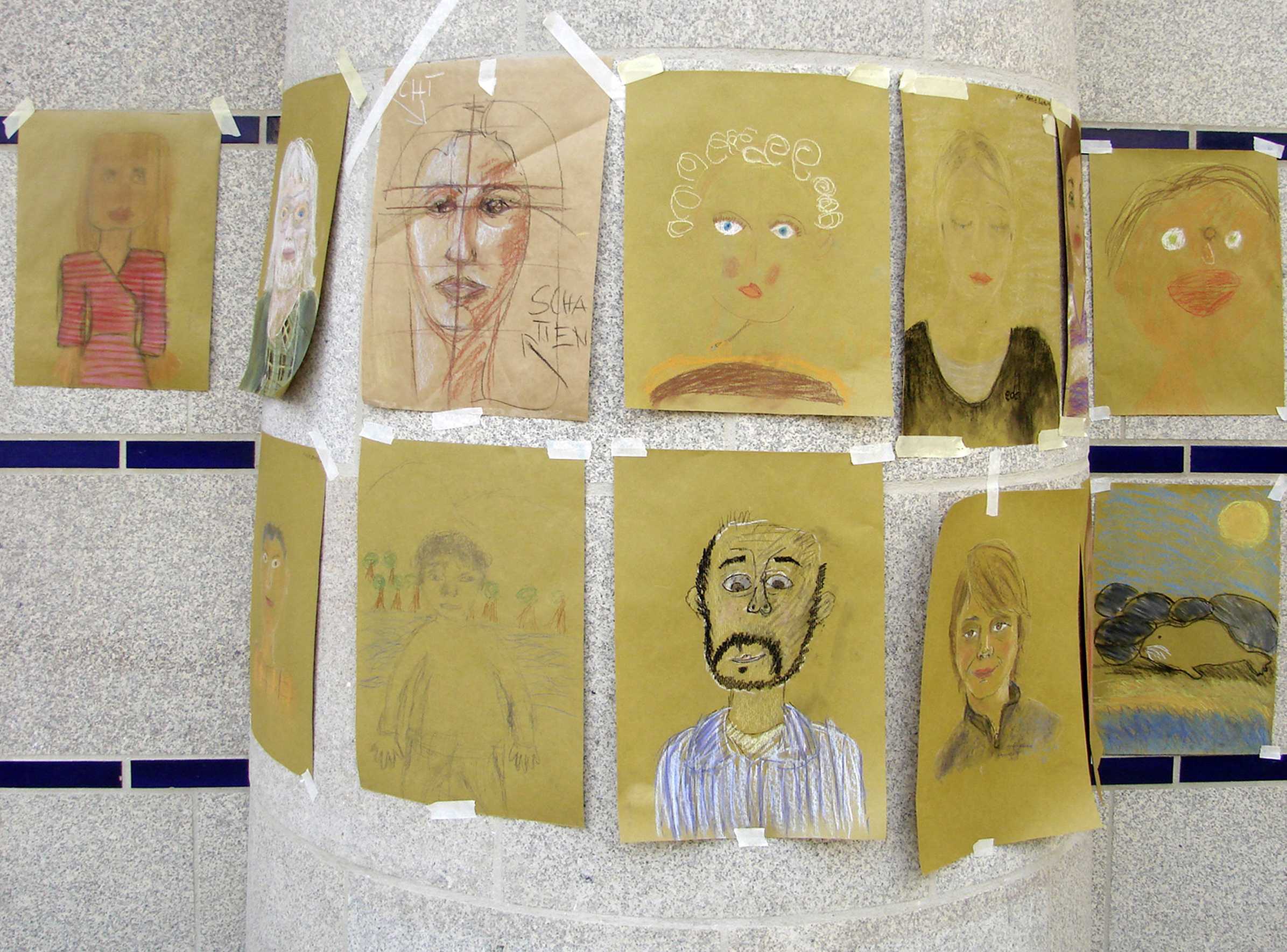 Die Abbildung zeigt von Jugendlichen gestaltete Porträts, die an einer Wand im Museum präsentiert werden. Die Fotoaufnahme stammt von Pirko Schröder.