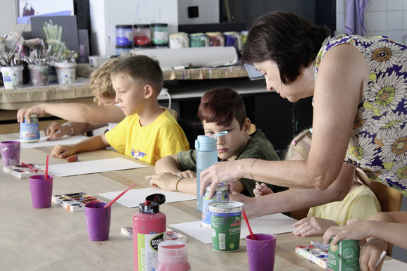 Die Abbildung zeigt Teilnehmende der Workshops zur Petrykiwka-Malerei beim kreativen Gestalten. Die Fotoaufnahme stammt von Kateryna Chebotarova.