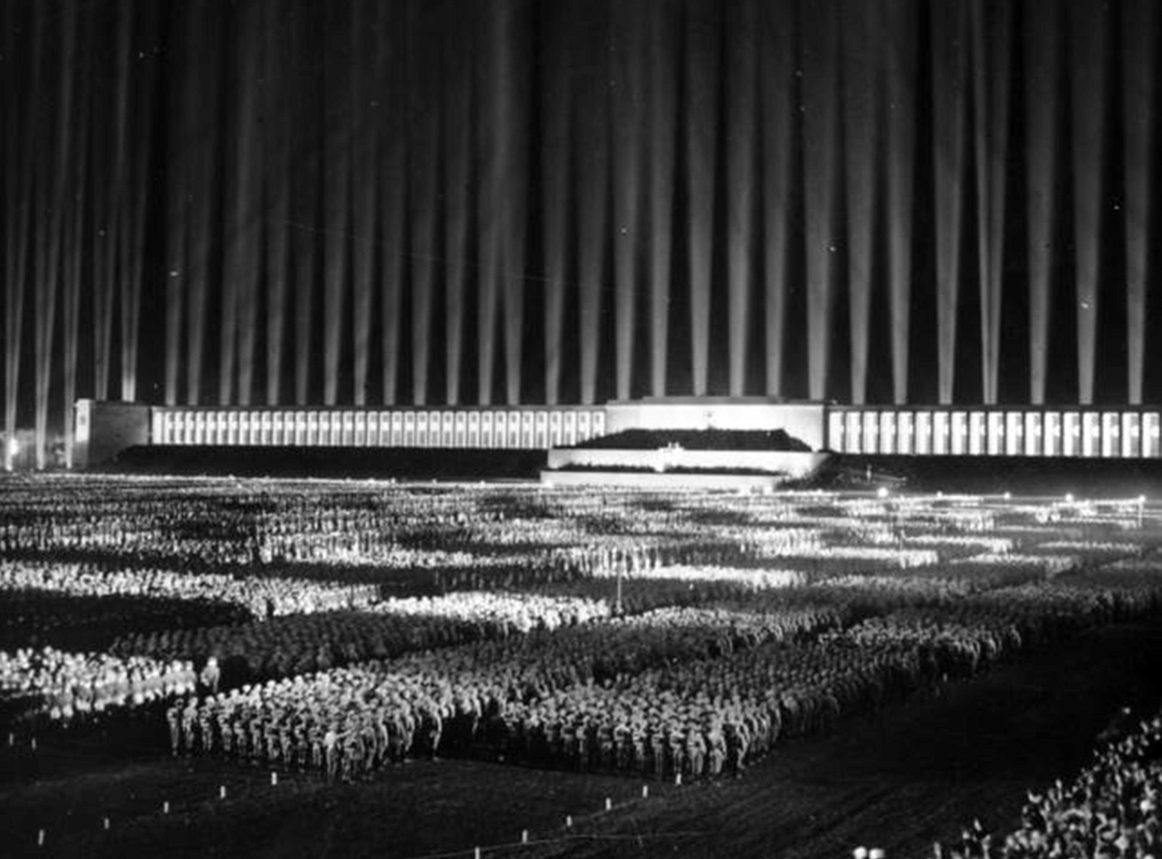 Die Abbildung zeigt den Ausschnitt einer Propagandapostkarte, auf der der inszenierte Lichtdom anlässlich des Reichsparteitags 1936 zu sehen ist. Die Aufnahme stammt aus dem Bundesarchiv und trägt die Signatur Bild 183-1982-1130-502.