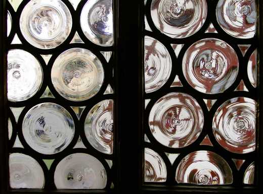 Die Abbildung zeigt die Glaselemente einer Butzenfensterscheibe im Albrecht-Dürer-Haus. Die Fotoaufnahme stammt von Pirko Schröder.