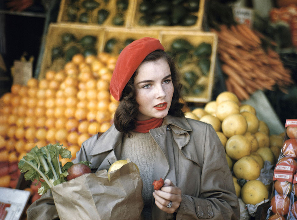 Die Abbildung zeigt eine von Ruth Orkin angefertigte Fotoaufnahme. Sie zeigt eine Frau, Geraldine Dent, beim Einkauf von Obst und Gemüse in New York City, 1949.