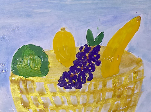 Die Abbildung zeigt ein von einem Kind gemaltes Stillleben. Es sind Früchte in einem Korb, Besteck und eine Flasche zu sehen. Die Fotoaufnahme stammt von Christine Arnold.