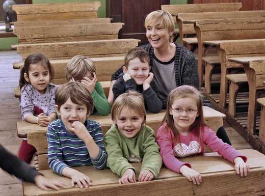 Die Abbildung zeigt eine Kindergruppe beim Besuch des historischen Schulzimmers im Museum Industriekultur. Die Kinder sitzen in den originalen historischen Schulbänken. Die Fotoaufnahme stammt von Thomas Ruppenstein.
