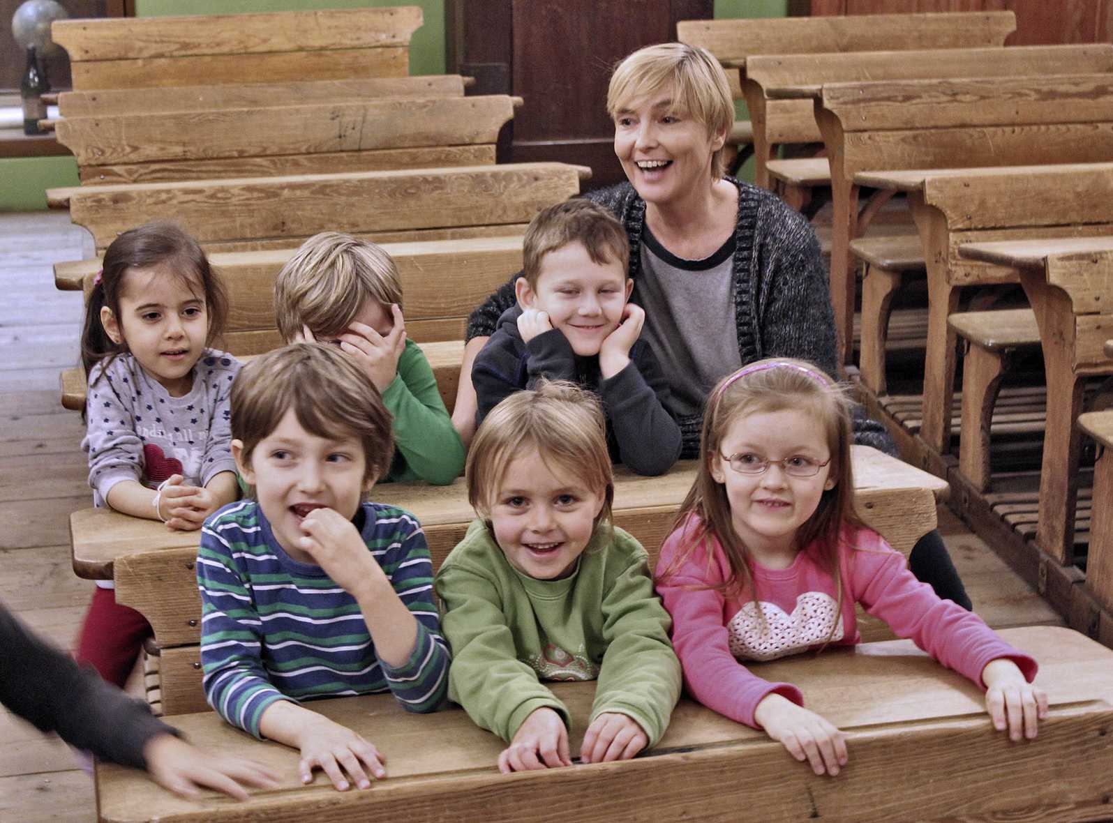 Die Abbildung zeigt eine Kindergruppe beim Besuch des historischen Schulzimmers im Museum Industriekultur. Die Kinder sitzen in den originalen historischen Schulbänken. Die Fotoaufnahme stammt von Thomas Ruppenstein.