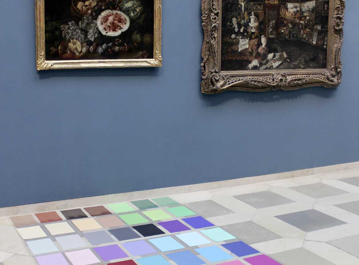 Die Abbildung zeigt Farbtafeln, die vor einem Gemälde im Germanischen Nationalmuseum auf dem Boden liegen. Die Fotoaufnahme stammt von Thomas Ruppenstein.