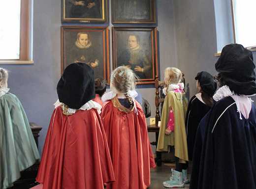 Die Abbildung zeigt Kinder im Kindergartenalter, die historischen Verkleidungen den Festsaal des Museums Tucherschloss erkunden. Die Fotoaufnahme stammt von Thomas Ruppenstein.