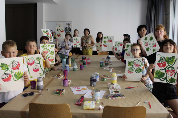 Die Abbildung zeigt Teilnehmende der Workshops zur Petrykiwka-Malerei beim kreativen Gestalten. Die Fotoaufnahme stammt von Kateryna Chebotarova.