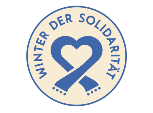 Die Abbildung zeigt das Logo zum Winter der Solidarität. Es ist rund und zeigt neben dem Schriftzug einen stilisierten Schal der ein Herz formt. Die Abbildung stammt von der Stadt Nürnberg.