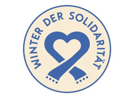 Die Abbildung zeigt das Logo zum Winter der Solidarität. Es ist rund und zeigt neben dem Schriftzug einen stilisierten Schal der ein Herz formt. Die Abbildung stammt von der Stadt Nürnberg.