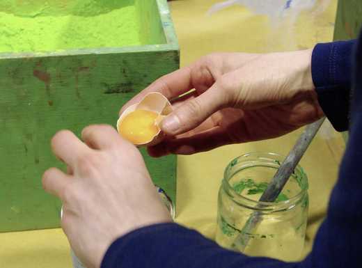 Die Abbildung zeigt Hände, die gerade ein Ei trennen. Das Eigelb wird bei dem Angebot zur Herstellung von Eitempera-Farbe verwendet. Die Fotoaufnahme stammt von Pirko Schröder.